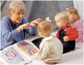 teacher telling stories to three toddlers